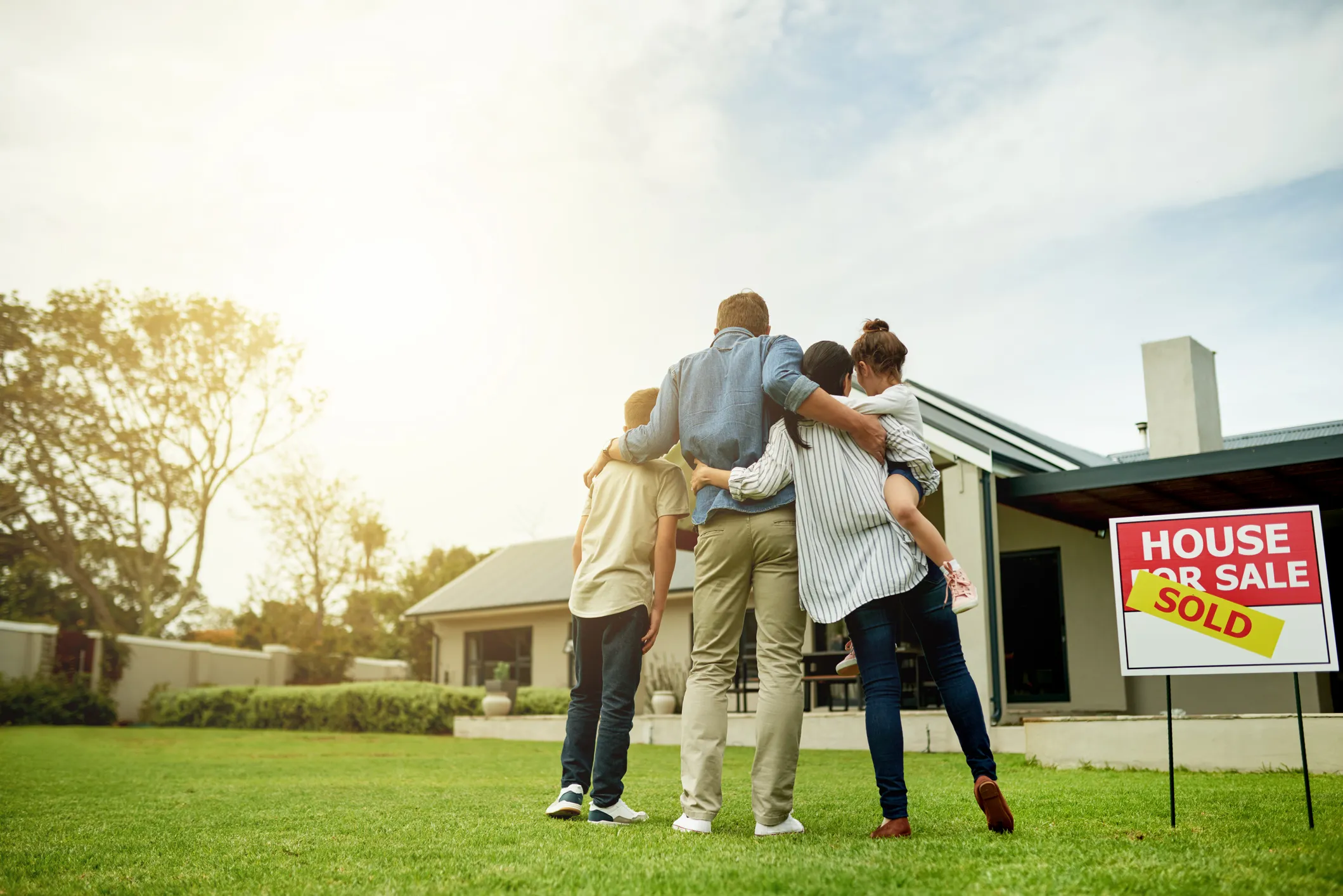A family embracing outside their new home